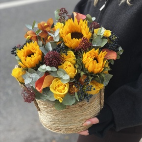 Композиция в сумке "Тональность" из подсолнухов, калл, ягод вибирнума, лимонных роз, скиммии и орхидеи в Мытищах
